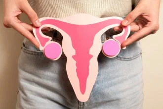 Woman holding a papercut reproductive system front view