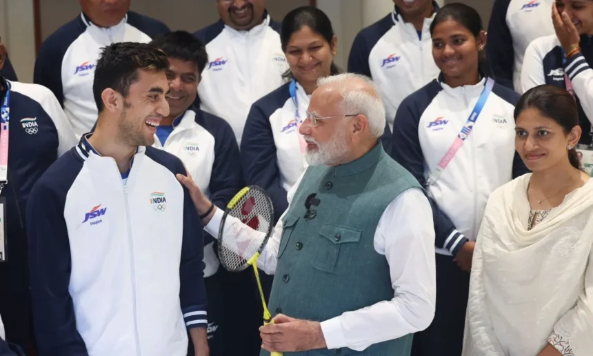 A picture of PM Modi having a friendly chat with Lakshya Sen while posing with the other Olympic players