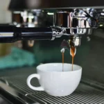 An image of coffee pouring into a white cup from a machine