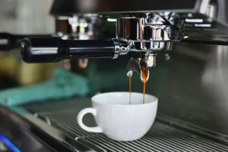 An image of coffee pouring into a white cup from a machine