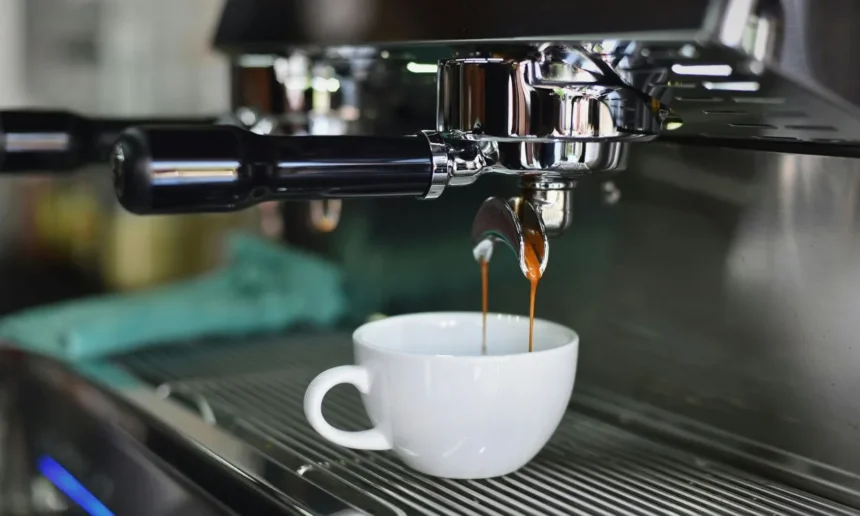 An image of coffee pouring into a white cup from a machine