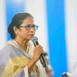 Mamata Banerjee holding a microphone and speaking