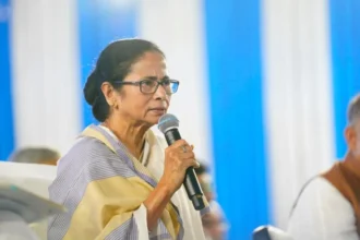 Mamata Banerjee holding a microphone and speaking